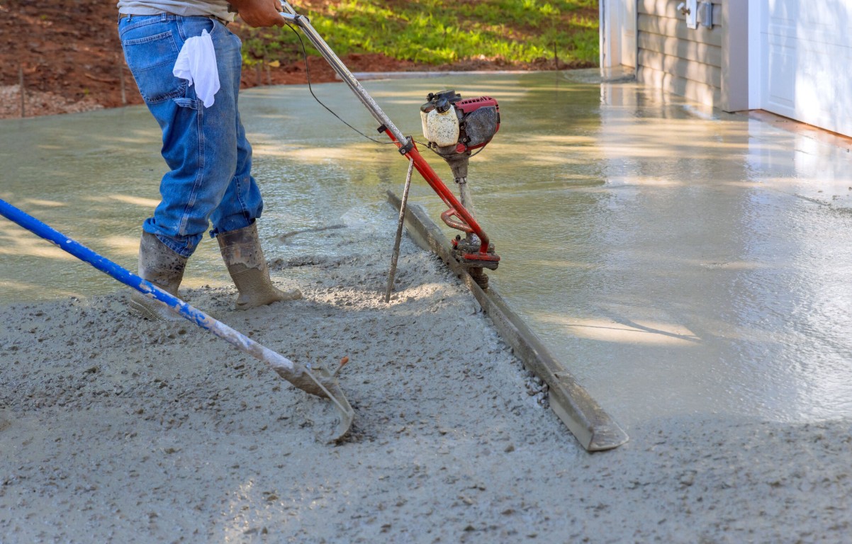 Concrete contractor using power finishing machine for smooth results
